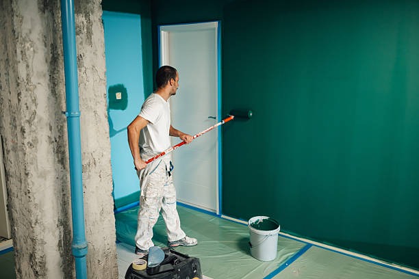imgi 14 painter painting a wall with a paint roller in a room being renovated imgi 14 painter painting a wall with a paint roller in a room being renovated